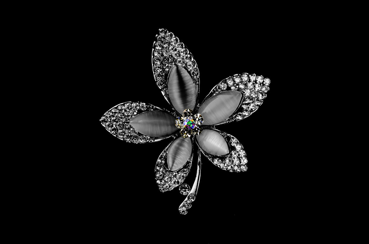 A flower shaped brooch with a diamond center